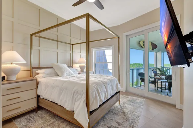 a bedroom with a bed lamp and a large window