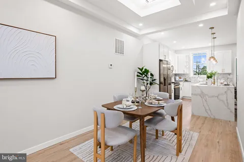 a kitchen with stainless steel appliances granite countertop a stove a refrigerator and a wooden floor