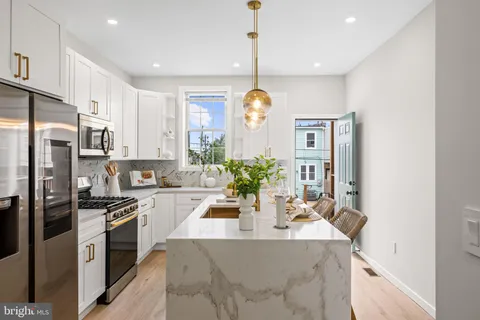 a kitchen with stainless steel appliances kitchen island granite countertop a sink a stove and cabinets