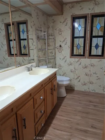 a bathroom with a double vanity sink a toilet and a mirror