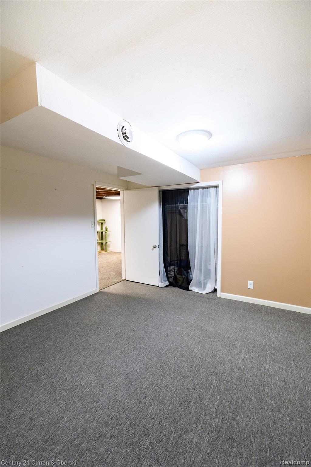 5260 Rives Junction Road Jackson, MI 49201 - Photo 31 of 44 Spacious room featuring neutral carpeting, a white ceiling with a flush-mount light fixture, and walls painted in contrasting white and warm beige tones