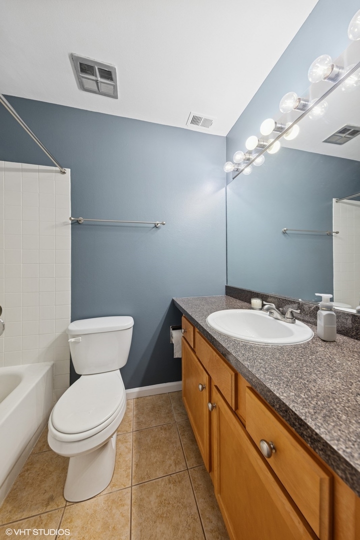 5900 Forest View Road, Unit 2A Lisle, IL 60532 - Photo 12 of 24 a bathroom with a granite countertop sink a toilet and bathtub