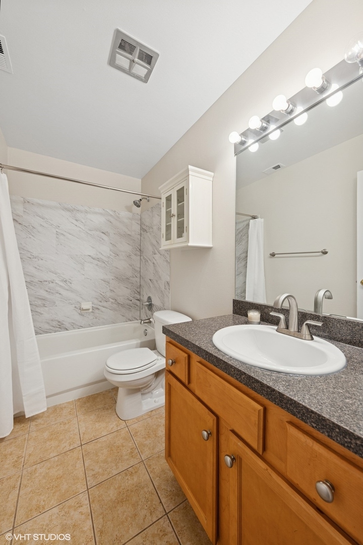 5900 Forest View Road, Unit 2A Lisle, IL 60532 - Photo 16 of 24 a bathroom with a granite countertop sink a toilet a mirror and bathtub