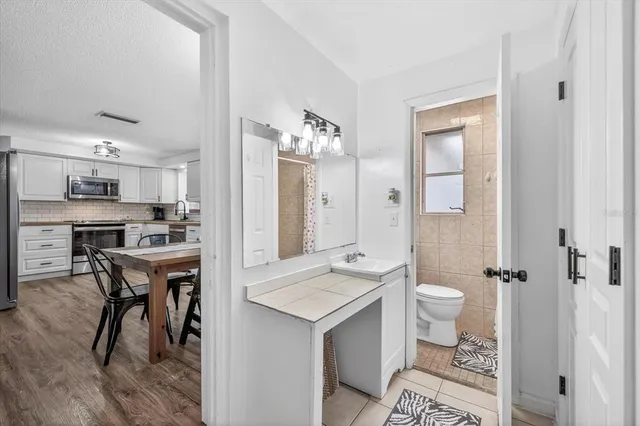 a spacious bathroom with a sink a toilet a mirror and a shower