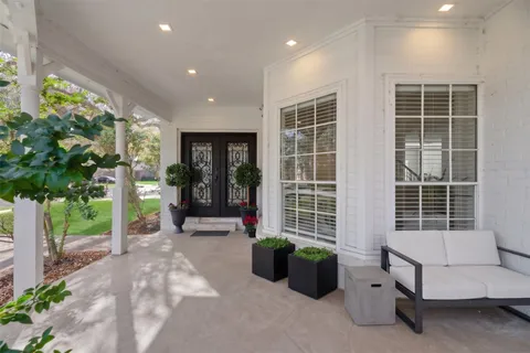 a spacious bedroom with a bed a couch and a large window