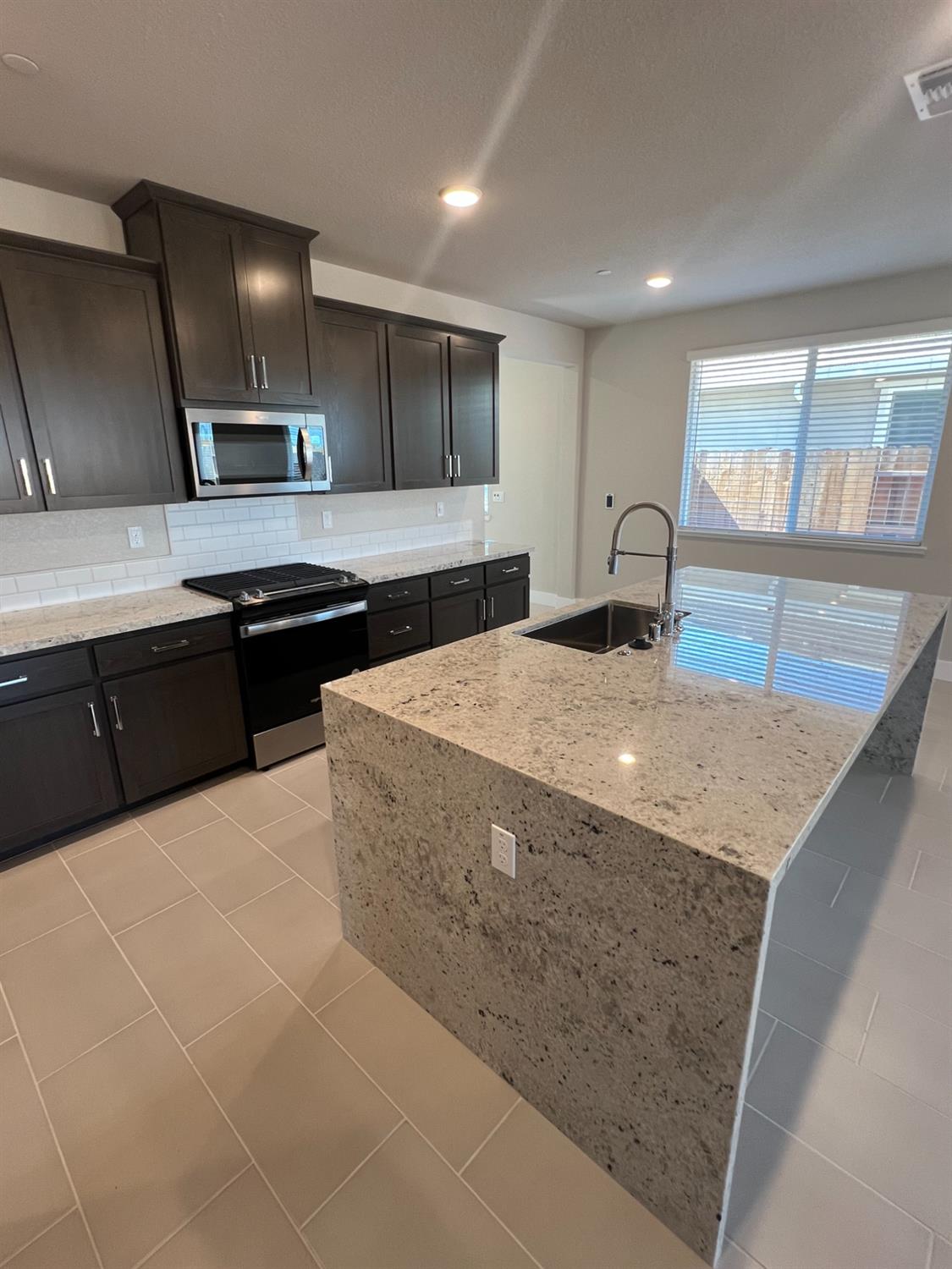 3063 Banano Way Rancho Cordova, CA 95742 - Photo 3 of 20 a kitchen with stainless steel appliances granite countertop a sink and a stove