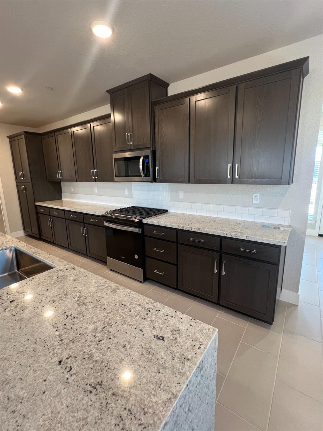 3063 Banano Way Rancho Cordova, CA 95742 - Photo 4 of 20 a kitchen with stainless steel appliances granite countertop wooden cabinets a sink and dishwasher