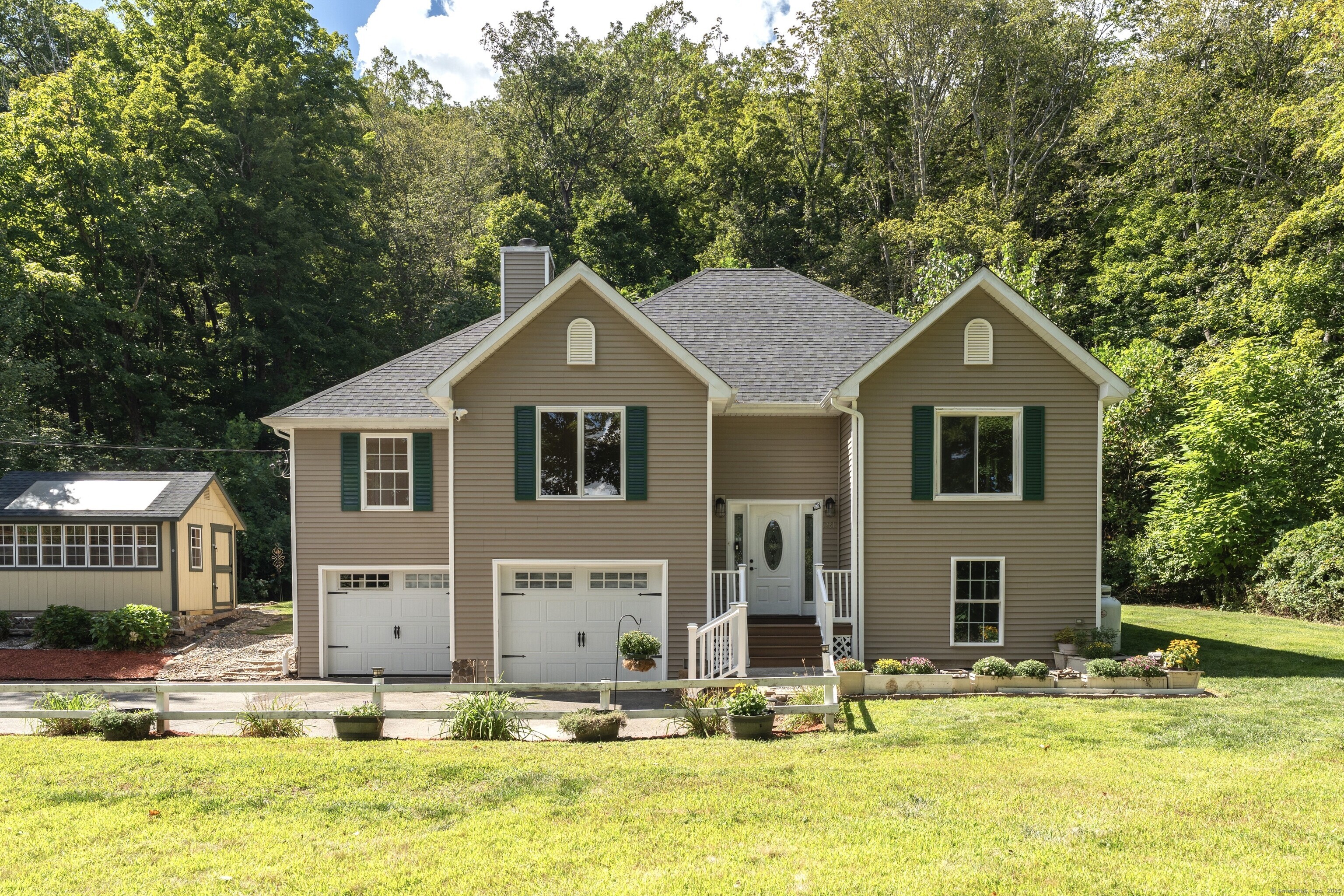 a front view of house with yard and trees around
