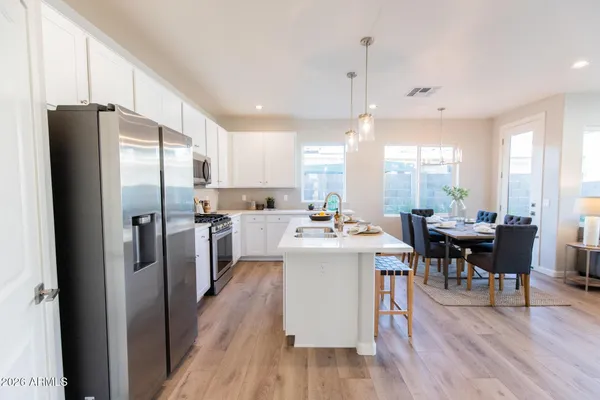 a kitchen with refrigerator a island and chairs