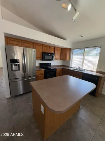 a kitchen with stainless steel appliances a refrigerator a stove a sink and a refrigerator