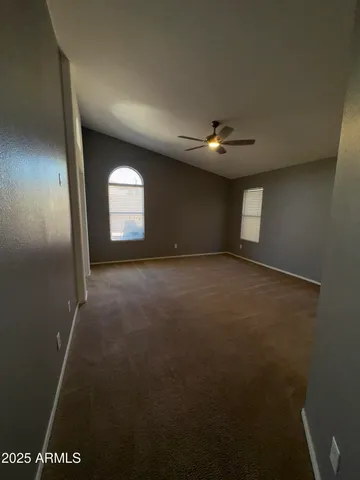an empty room with windows and fan