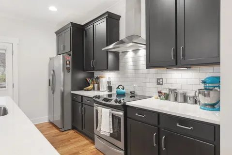 a kitchen with stainless steel appliances granite countertop a sink stove and refrigerator