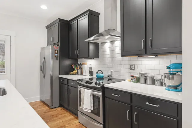 a kitchen with stainless steel appliances granite countertop a sink stove and refrigerator