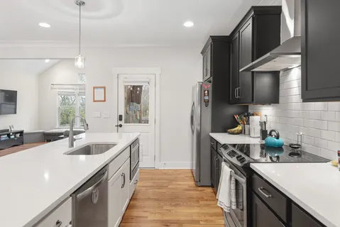 a kitchen with granite countertop a sink a counter space appliances and cabinets