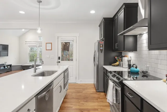 a kitchen with granite countertop a sink a counter space appliances and cabinets