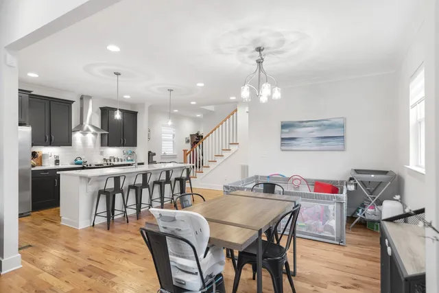 a living room with dining table and wooden floor