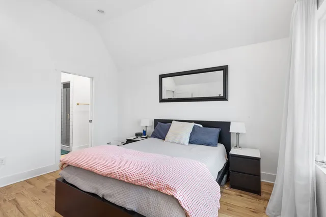 a bedroom with a bed and wooden floor