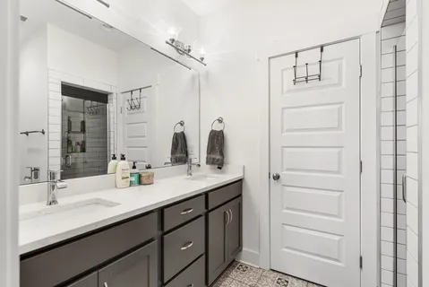 a bathroom with a double vanity sink and a mirror
