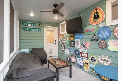 a room with stainless steel appliances a rug and a chandelier
