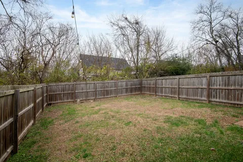 a view of a backyard with wooden fence