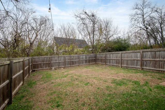 a view of a backyard with wooden fence