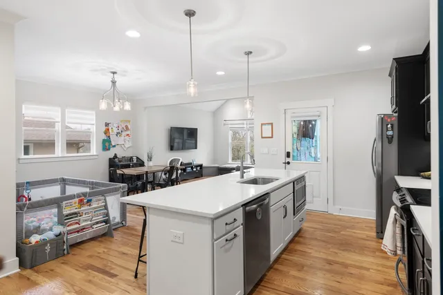 a large kitchen with stainless steel appliances kitchen island granite countertop a sink a counter space and a window