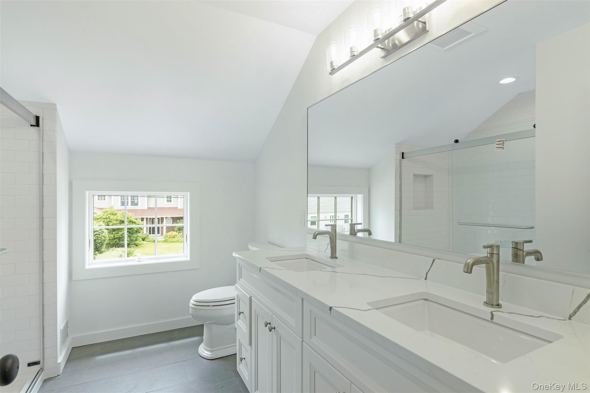 130 Sunset Lane Greenport, NY 11944 - Photo 21 of 34 Full bathroom featuring lofted ceiling, plenty of natural light, double vanity, a shower stall, and tile patterned floors