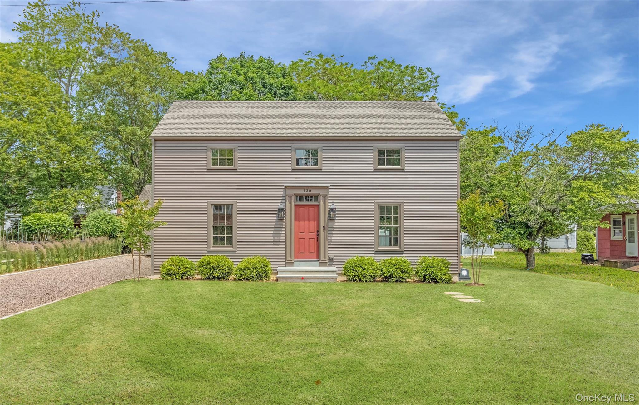 130 Sunset Lane Greenport, NY 11944 - Photo 33 of 34 Colonial-style house with a front yard, roof with shingles, and driveway