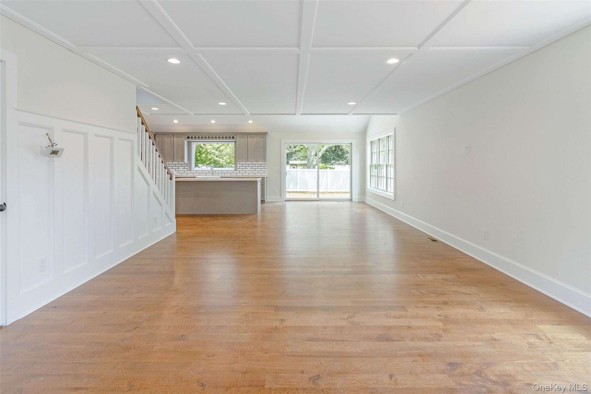 130 Sunset Lane Greenport, NY 11944 - Photo 4 of 34 Unfurnished living room featuring recessed lighting, light wood finished floors, a decorative wall, and stairway