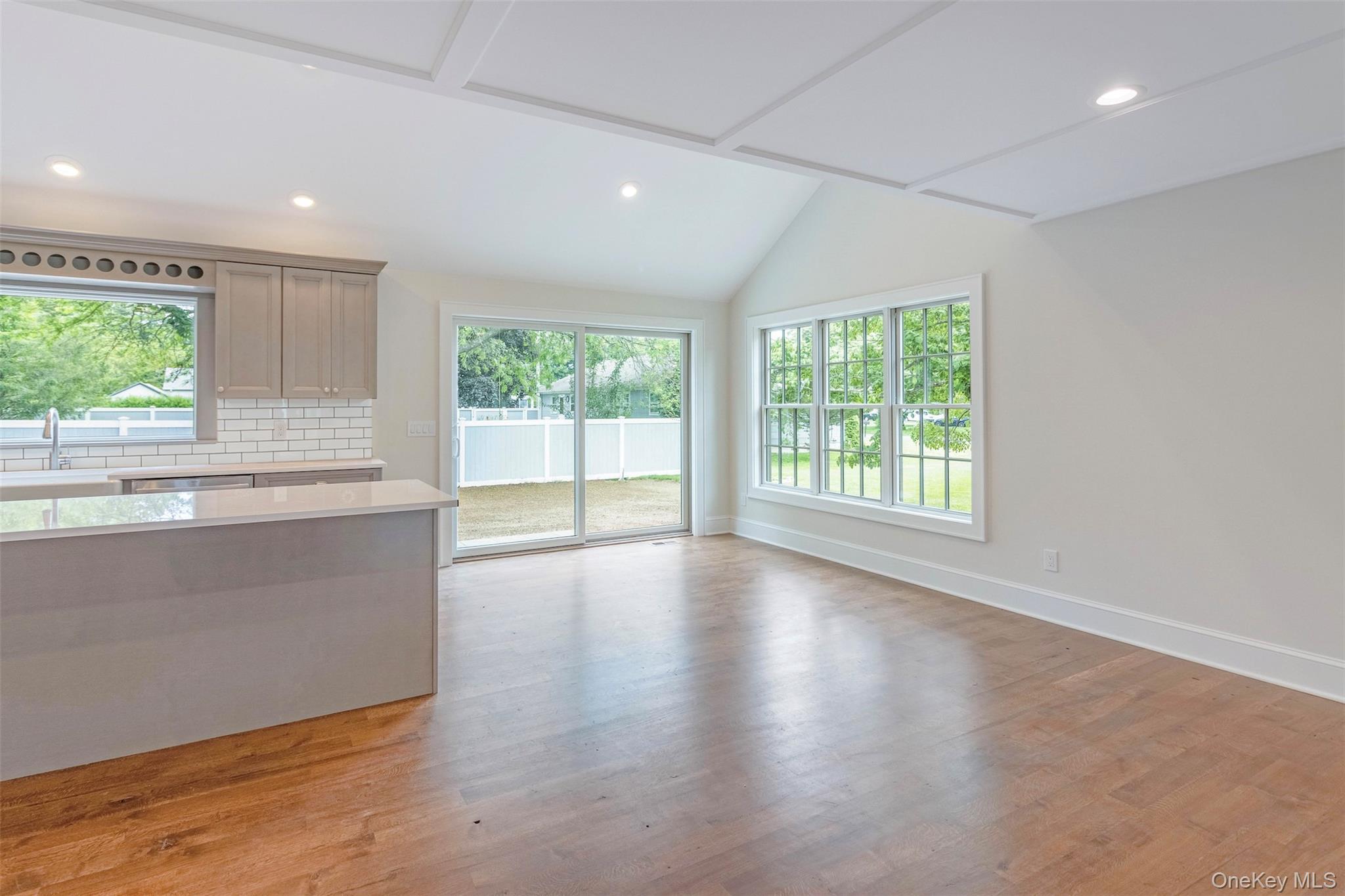 130 Sunset Lane Greenport, NY 11944 - Photo 5 of 34 Unfurnished living room with light wood-style flooring, recessed lighting, and vaulted ceiling