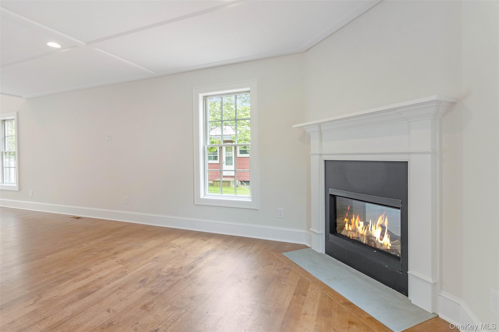 130 Sunset Lane Greenport, NY 11944 - Photo 9 of 34 Unfurnished living room with a fireplace with flush hearth, light wood-style flooring, and recessed lighting
