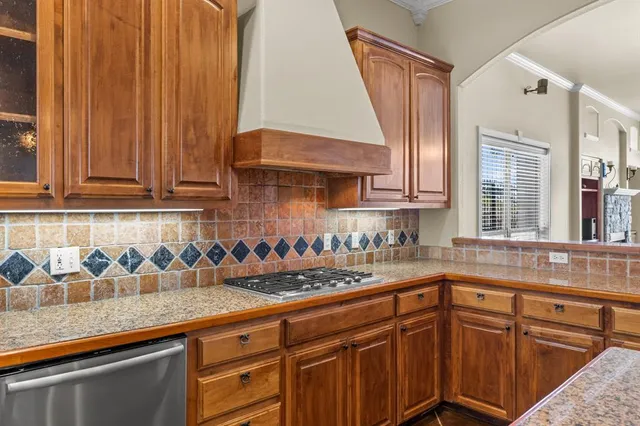 a kitchen with stainless steel appliances granite countertop a sink a stove and cabinets