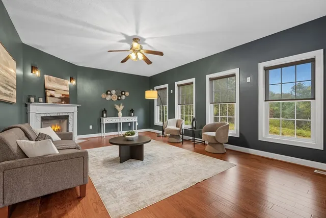 a living room with furniture large window and wooden floor