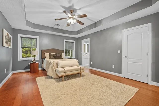 a spacious bedroom with a large bed and a chandelier