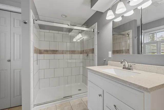 a bathroom with a sink a mirror and a shower