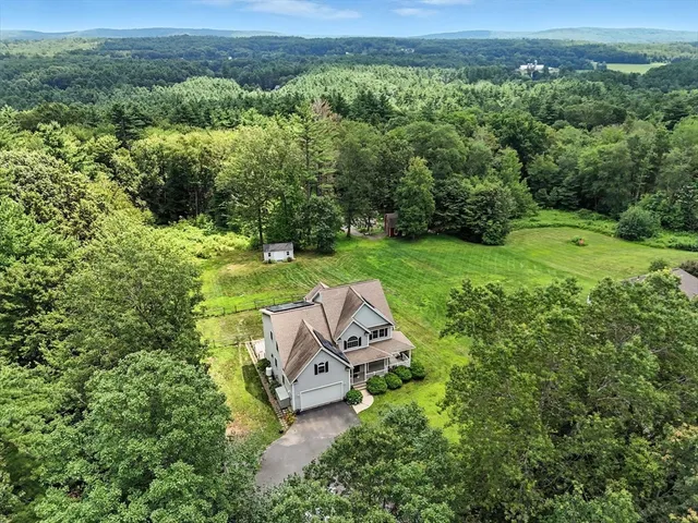 an aerial view of a house with a yard and lake view