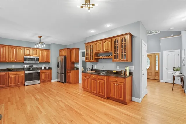 a kitchen with stainless steel appliances granite countertop a stove a sink dishwasher and a refrigerator