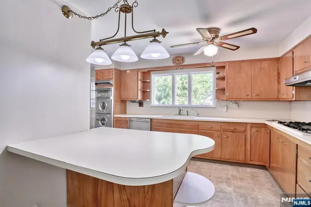 a kitchen with stainless steel appliances a table chairs and chandelier