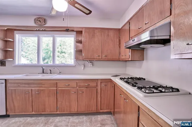 a kitchen with cabinets appliances a sink and a window