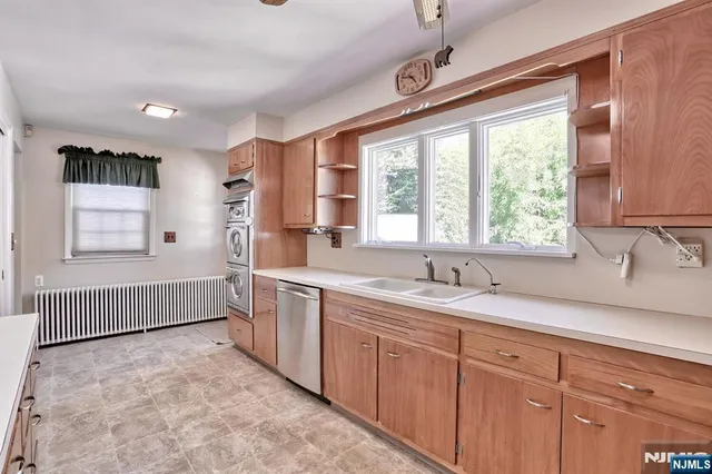 a spacious bathroom with a granite countertop sink mirror and a large window
