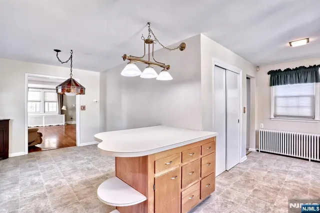 a room with a chandelier and a dresser