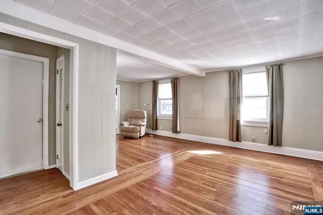 a view of a livingroom with wooden floor and a bathroom