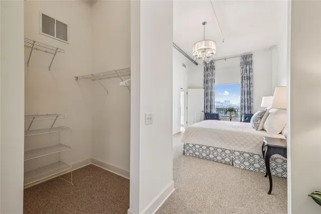 a bedroom with a bed chandelier and a window