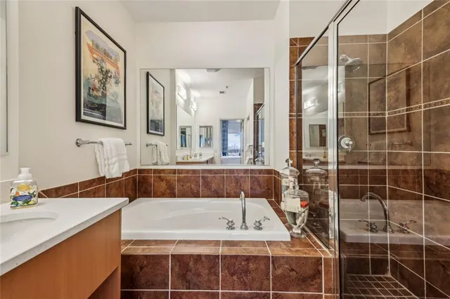 a bathroom with a tub a sink and glass door