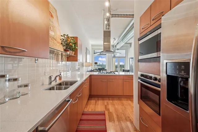 a kitchen with stainless steel appliances granite countertop a sink and stove top oven