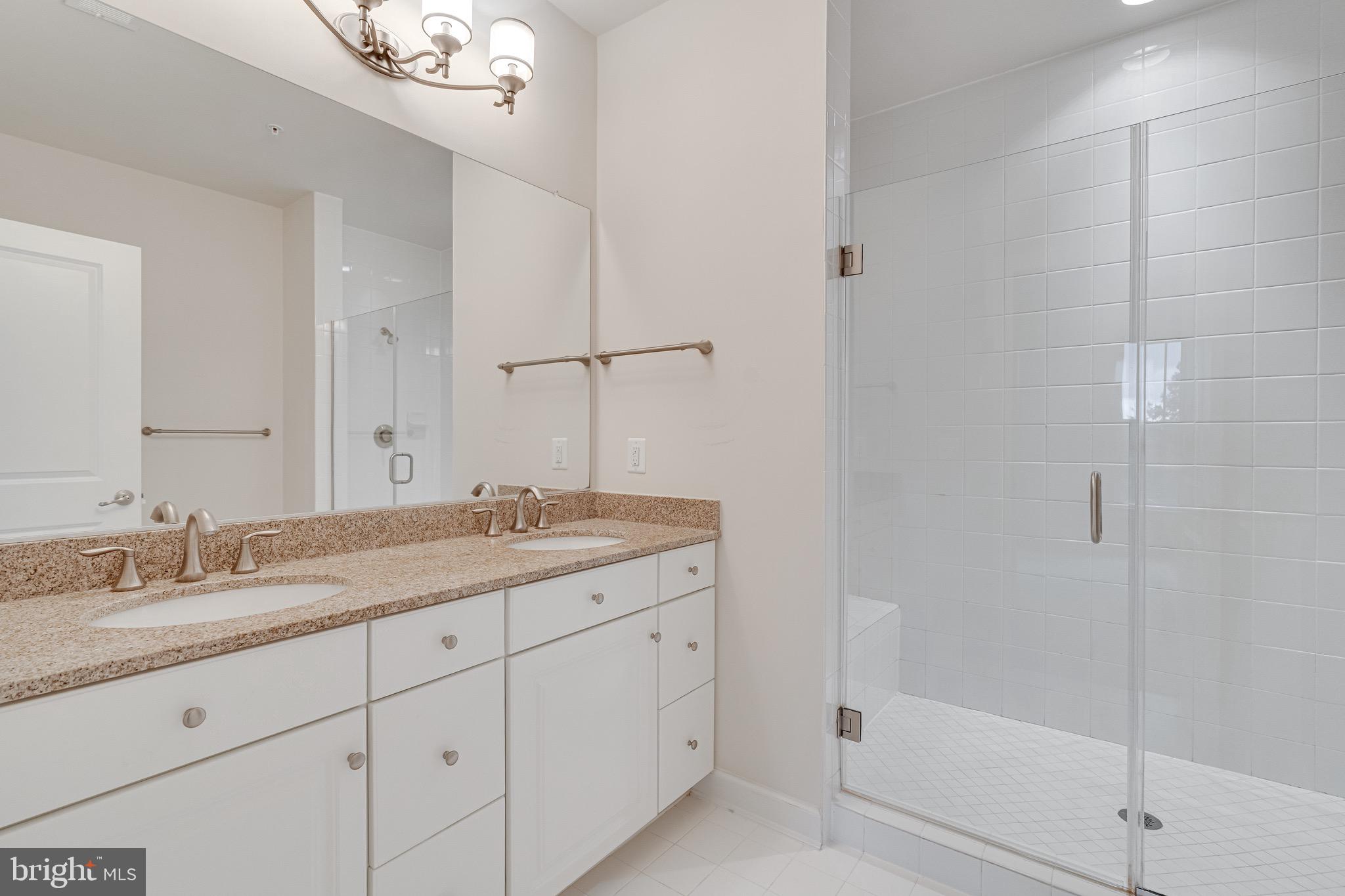 11357 Ridgeline Road Fairfax, VA 22030 - Photo 26 of 57 a bathroom with a granite countertop sink a mirror and a shower