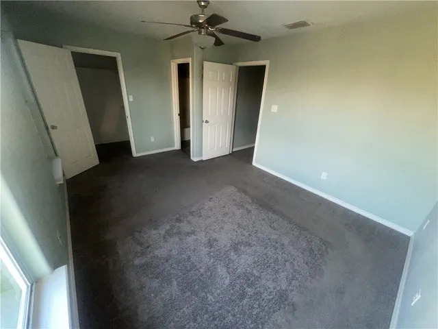 an empty room with windows and cabinet
