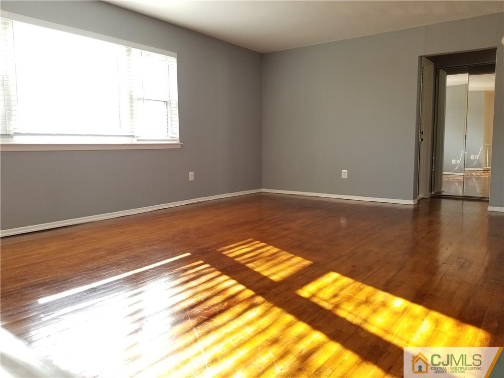 197 Evergreen Road, Unit 3B Edison, NJ 08837 - Photo 14 of 20 a view of a room with wooden floor and a window