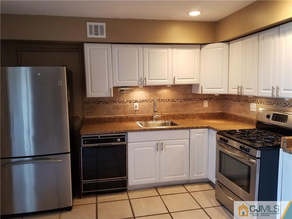 197 Evergreen Road, Unit 3B Edison, NJ 08837 - Photo 9 of 20 a kitchen with stainless steel appliances granite countertop a stove a refrigerator and a sink