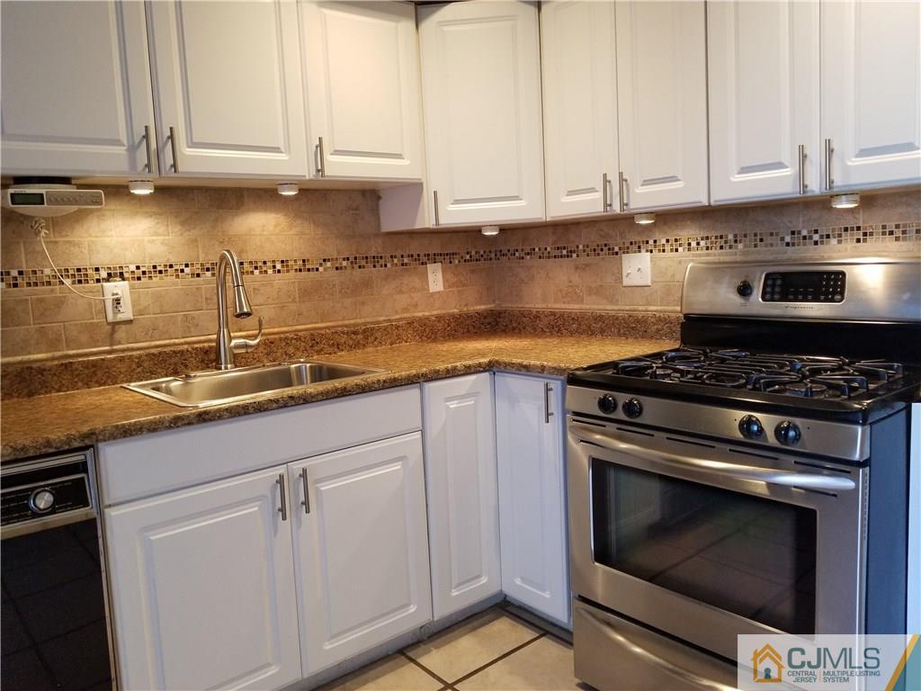 197 Evergreen Road, Unit 3B Edison, NJ 08837 - Photo 10 of 20 a kitchen with granite countertop a stove and a sink
